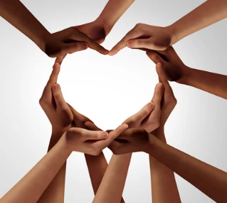 Hands of many different skin tones cupped together to form the shape of a heart