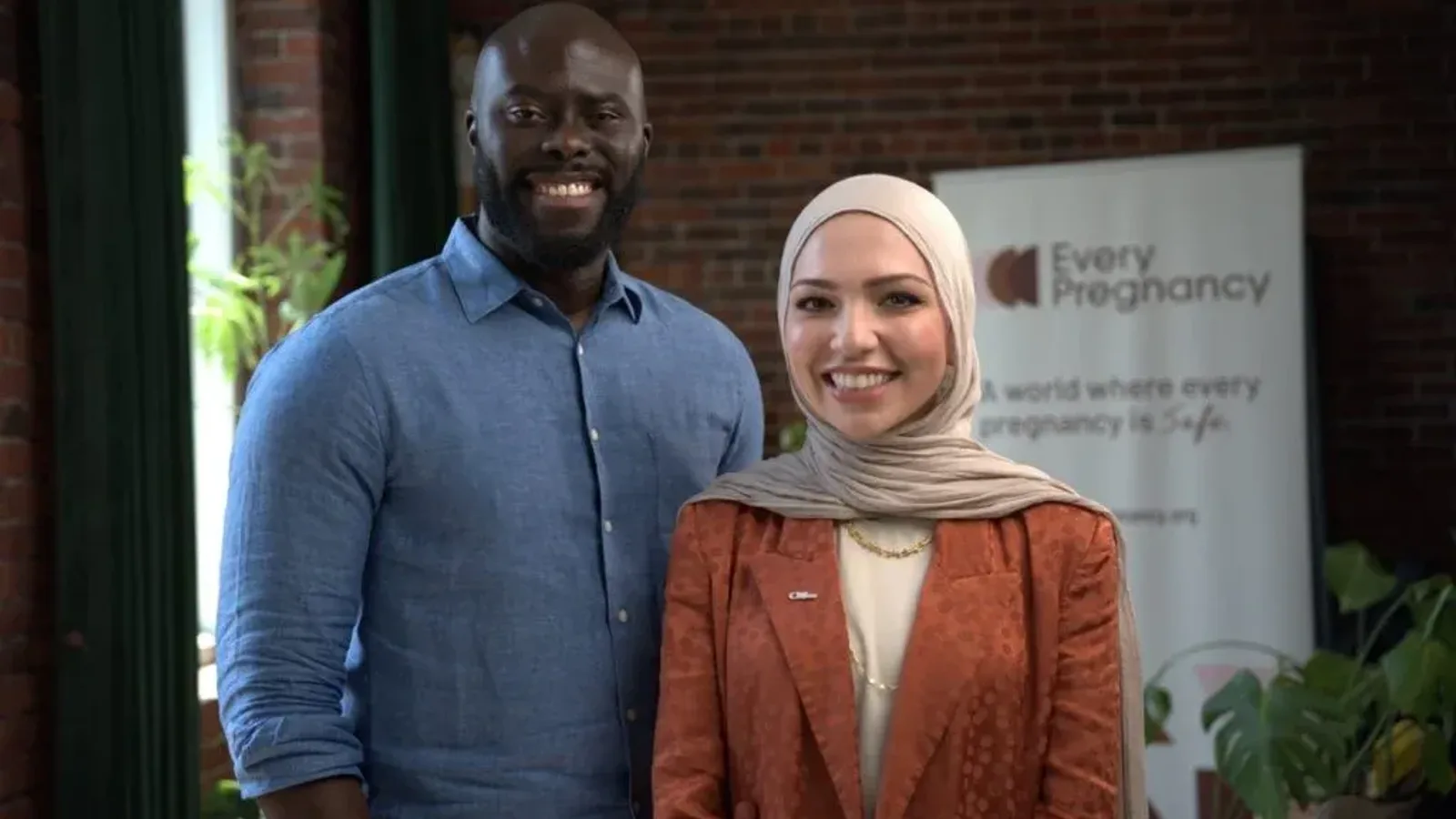 Emmanuel Akpakwu of Axmed and Isra Chaker of Every Pregnancy standing together in front of an Every Pregnancy banner