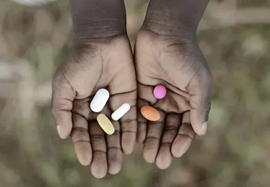 Two cupped hands holding assorted tablets