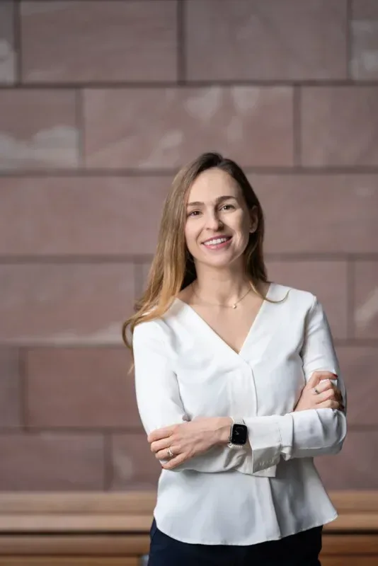 Sofia Radley-Searle, Co-Founder and COO of Axmed, standing with arms folded in front of a sandstone wall